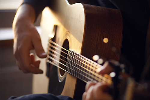 Person playing an acoustic guitar