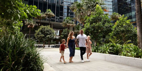 A wide hallway within Parramatta Square with abstract textures on either side and people walking through it.